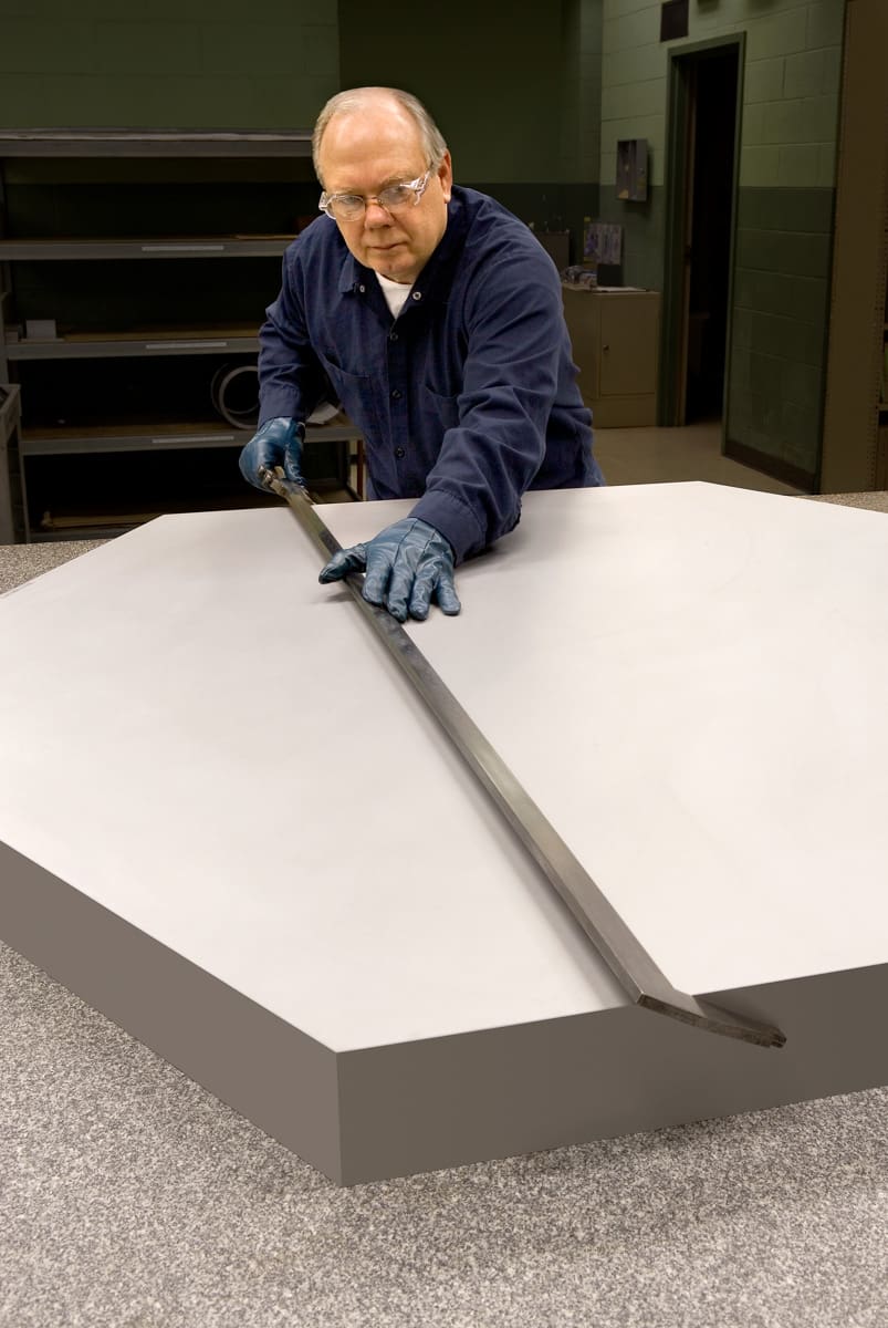 Materion employee checks the exact specifications of a beryllium metal mirror blank needed for the James Webb Space Telescope.